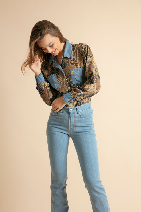 Laughing girl in straight jeans and denim printed shirt