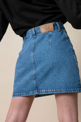 Short denim skirt with studs seen from behind