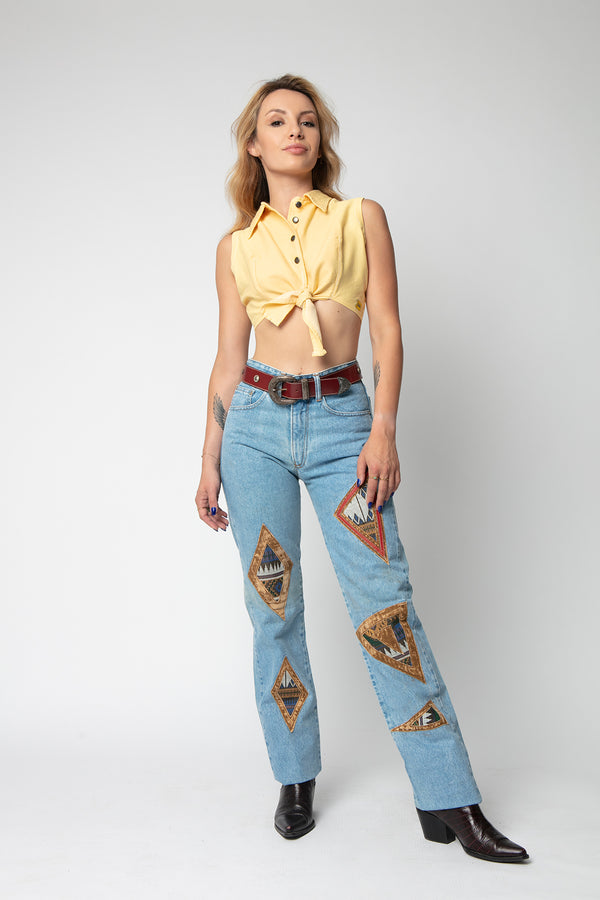 Woman in yellow top and light jeans with Indian patches