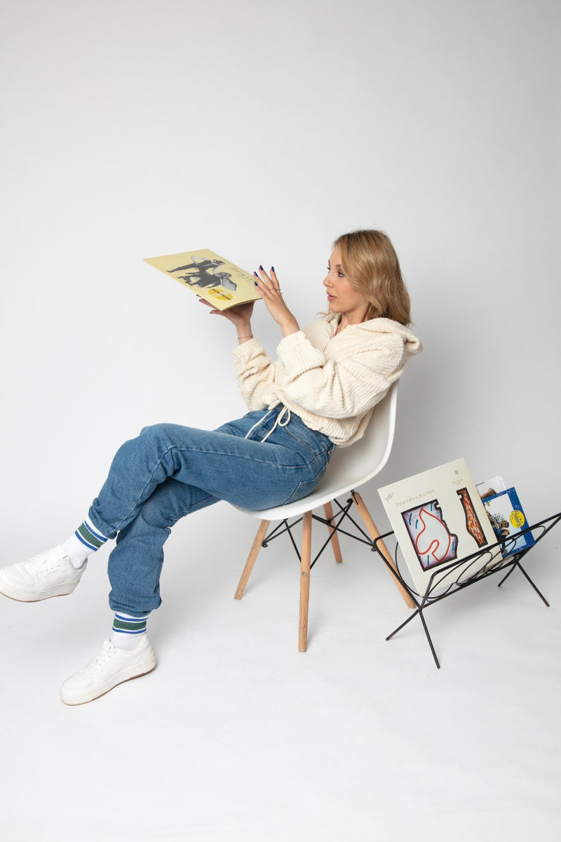 Girl in a chair with jeans and white sweatshirt